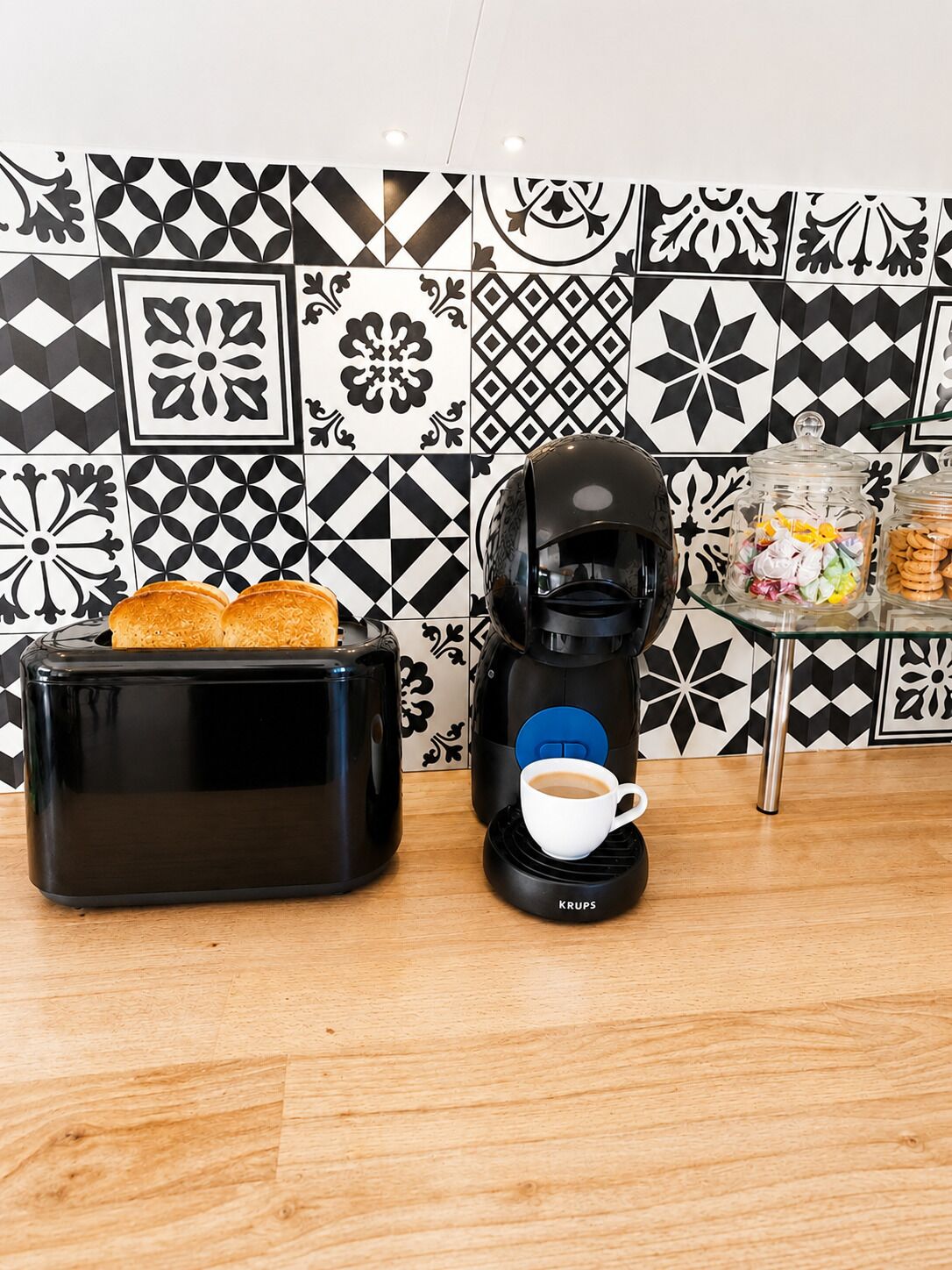 Eine Küche mit einem Toaster, einer Kaffeemaschine und einem Glas mit Keksen.