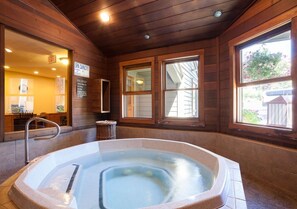 A spa with a capacity of 5 persons, a hot tub, wooden walls, and windows with a view. - 2BR Mountain Condo | Walk to Resort, Hot Tubs, Pool (Steamboat Springs)