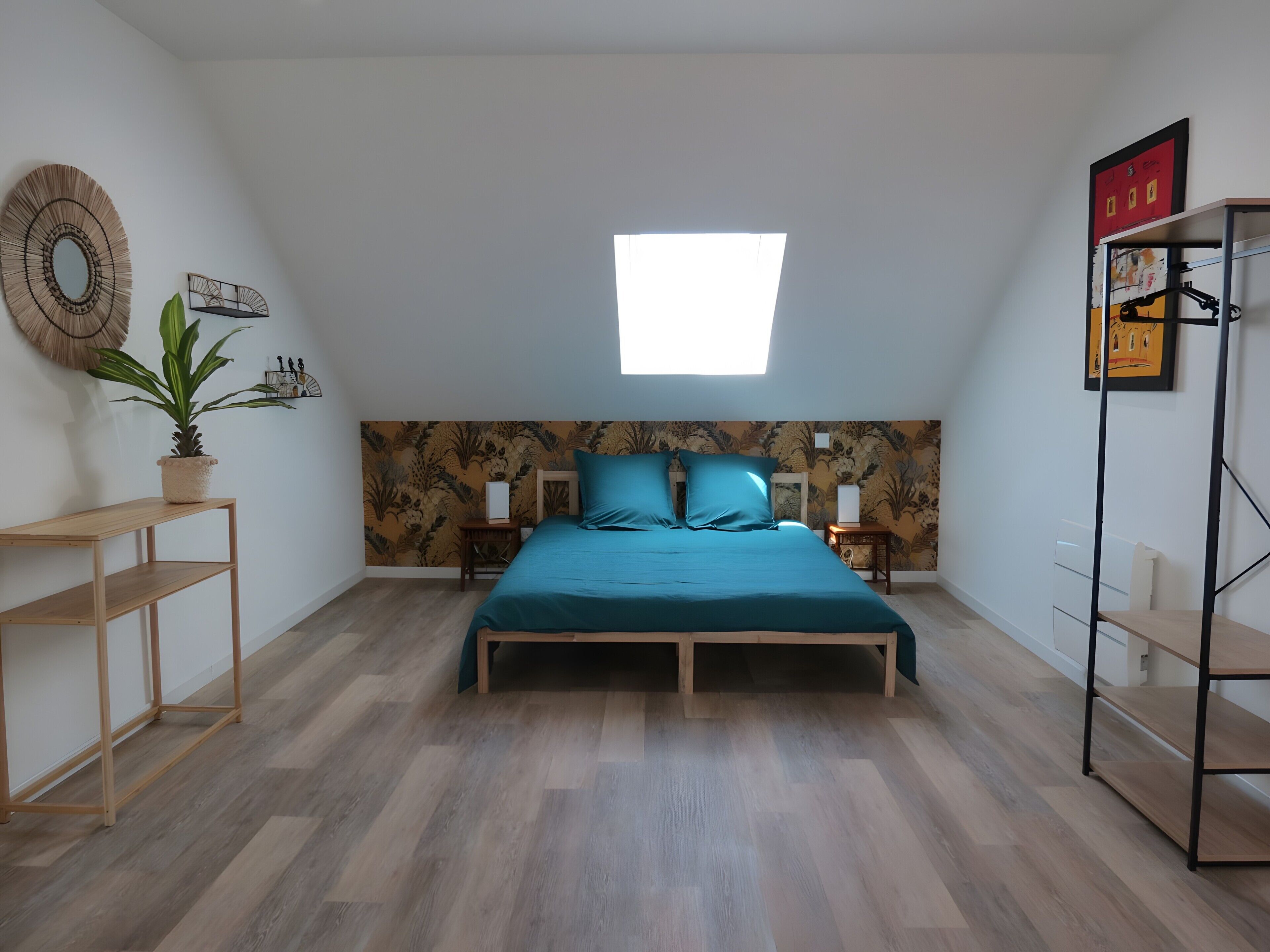 Ein Schlafzimmer mit Bett, Oberlicht, einer Topfpflanze, einem Regal und einem Kleiderschrank.