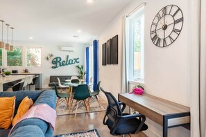 Ein modernes Wohnzimmer mit einer Couch, einem Essbereich und einem Schreibtisch.