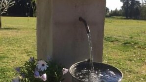 A water feature with a stone structure and a metal basin.