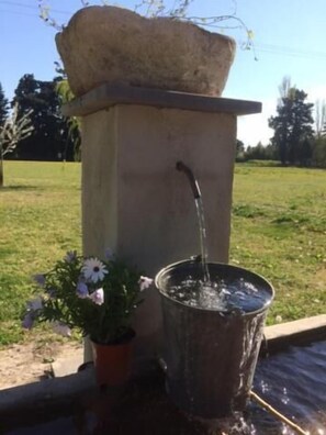 A water feature with a stone structure and a metal basin.