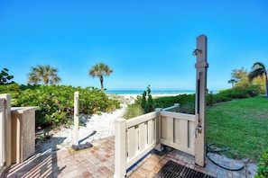 A beachside property with a gated entrance, a small garden, and a view of the ocean. - Remodeled Siesta Key Villa – Steps to Private Beach & Village! (Sarasota)