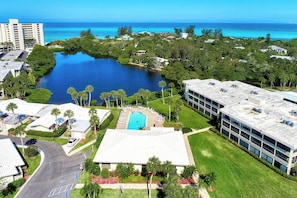A hotel with a swimming pool, a tennis court, and a view of the ocean. - Remodeled Siesta Key Villa – Steps to Private Beach & Village! (Sarasota)