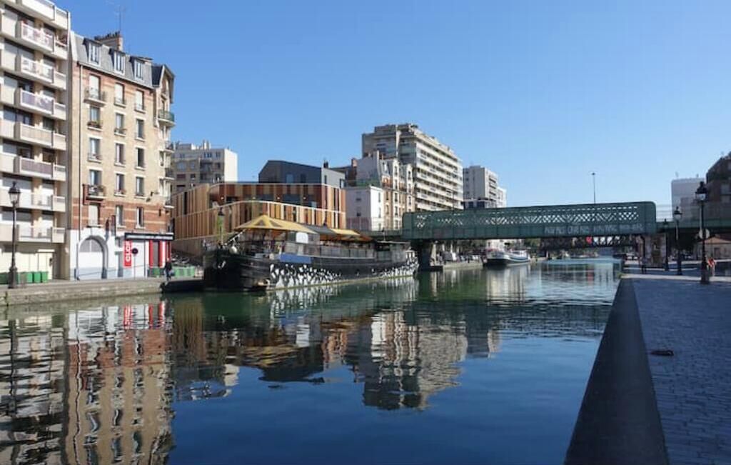 Un canal avec un pont, des bâtiments et un bateau.