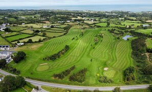 Un campo de golf con varios fairways, greens y búnkeres de arena.