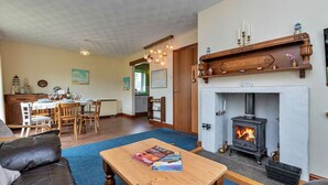 Ein Wohnzimmer mit Kamin, Essbereich und Küche.
