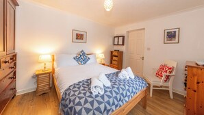 A bedroom with a bed, bedside tables, a chair, a wardrobe, and a door. - Quiet Green&Peaceful Home Near Reading University - Pass the Keys (Reading)