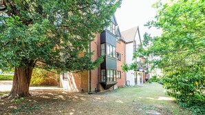 A two-story building with a brick facade, large windows, and a sloped roof. - Quiet Green&Peaceful Home Near Reading University - Pass the Keys (Reading)