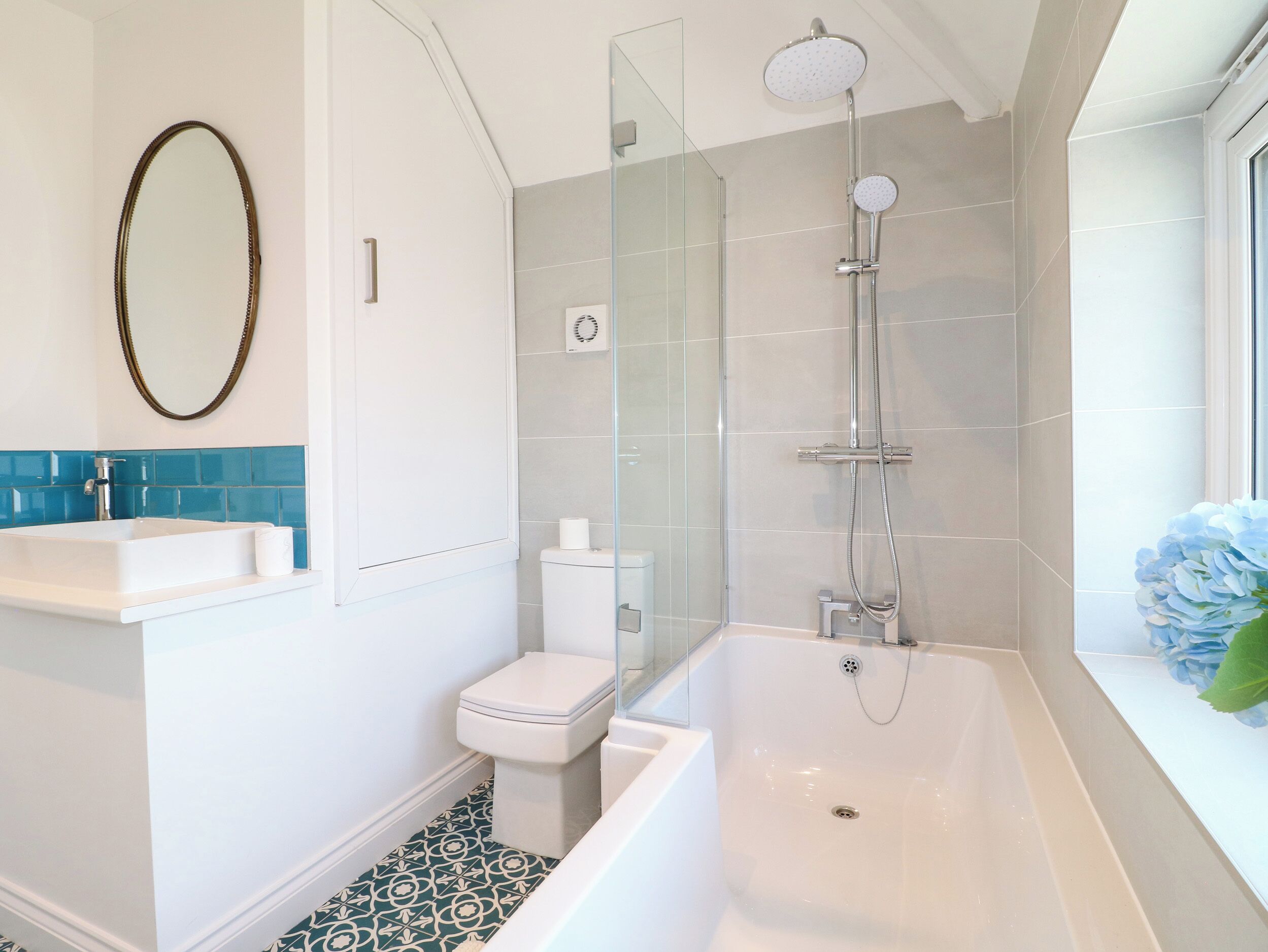 Un baño moderno con bañera, cabina de ducha con mampara de vidrio, inodoro y lavabo.