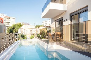 Ein modernes Gebäude mit Swimmingpool, Glasgeländern und Blick auf die umliegende Gegend.