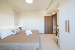 Ein modernes Schlafzimmer mit einem großen Bett, einem Nachttisch, einem Kleiderschrank und einer Tür zu einem anderen Raum.