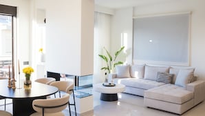 Uma sala de estar moderna com um sofá, mesa de centro e área de jantar.
