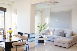 Ein modernes Wohnzimmer mit Sofa, Couchtisch und Essbereich.