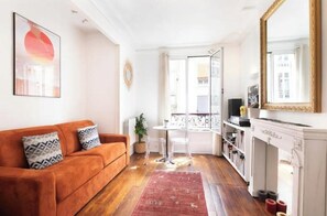 Ein Wohnzimmer mit Sofa, einem kleinen Tisch, einem Kamin und einem Balkon mit Blick.