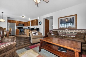 A living room with a sofa, armchairs, a coffee table, and a rug. - Lake front Eagle River Chain of Lakes with indoor pool and jacuzzi! (Eagle River)