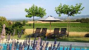 A poolside area with four lounge chairs and a pergola with an umbrella. - Tranquil French Gîte with Pool, A/C and Stunning Views Near Carcassonne (Raissac-sur-Lampy)