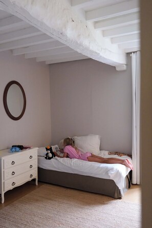 Un dormitorio con cama, cómoda y espejo.