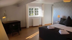 A bedroom with a bed, bedside lamps, a desk, and a window. - Tranquil French Gîte with Pool, A/C and Stunning Views Near Carcassonne (Raissac-sur-Lampy)