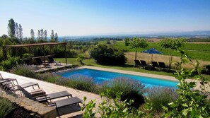 A pool with lounge chairs and a pergola, surrounded by greenery and a view of distant hills. - Tranquil French Gîte with Pool, A/C and Stunning Views Near Carcassonne (Raissac-sur-Lampy)