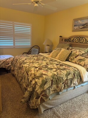 A bedroom with a bed, a chair, a lamp, and a ceiling fan. - Gulf-front paradise in Springtime on lovely Longboat Key 2/2 -2 pools,pickleball (Longboat Key)