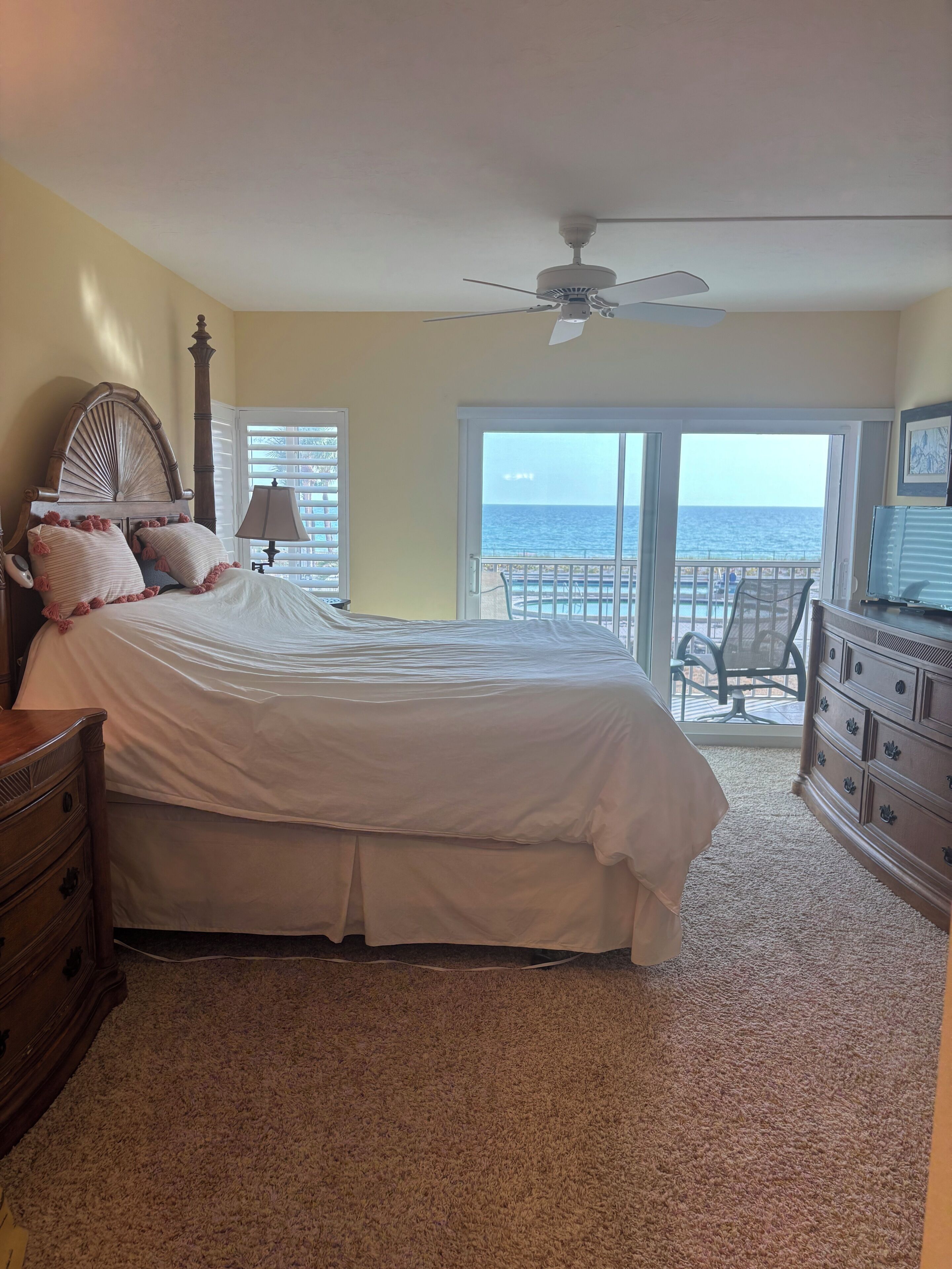 Ein Schlafzimmer mit Bett, Kommode und Meerblick.