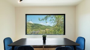 A conference room with a large window overlooking a green landscape and a view of houses. - Spacious 4BR mountain-view retreat near Old Town Park City. (Park City)
