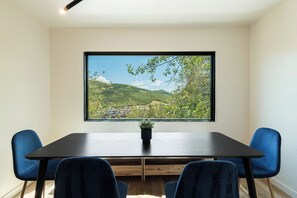 A conference room with a large window overlooking a green landscape and a view of houses. - Spacious 4BR mountain-view retreat near Old Town Park City. (Park City)