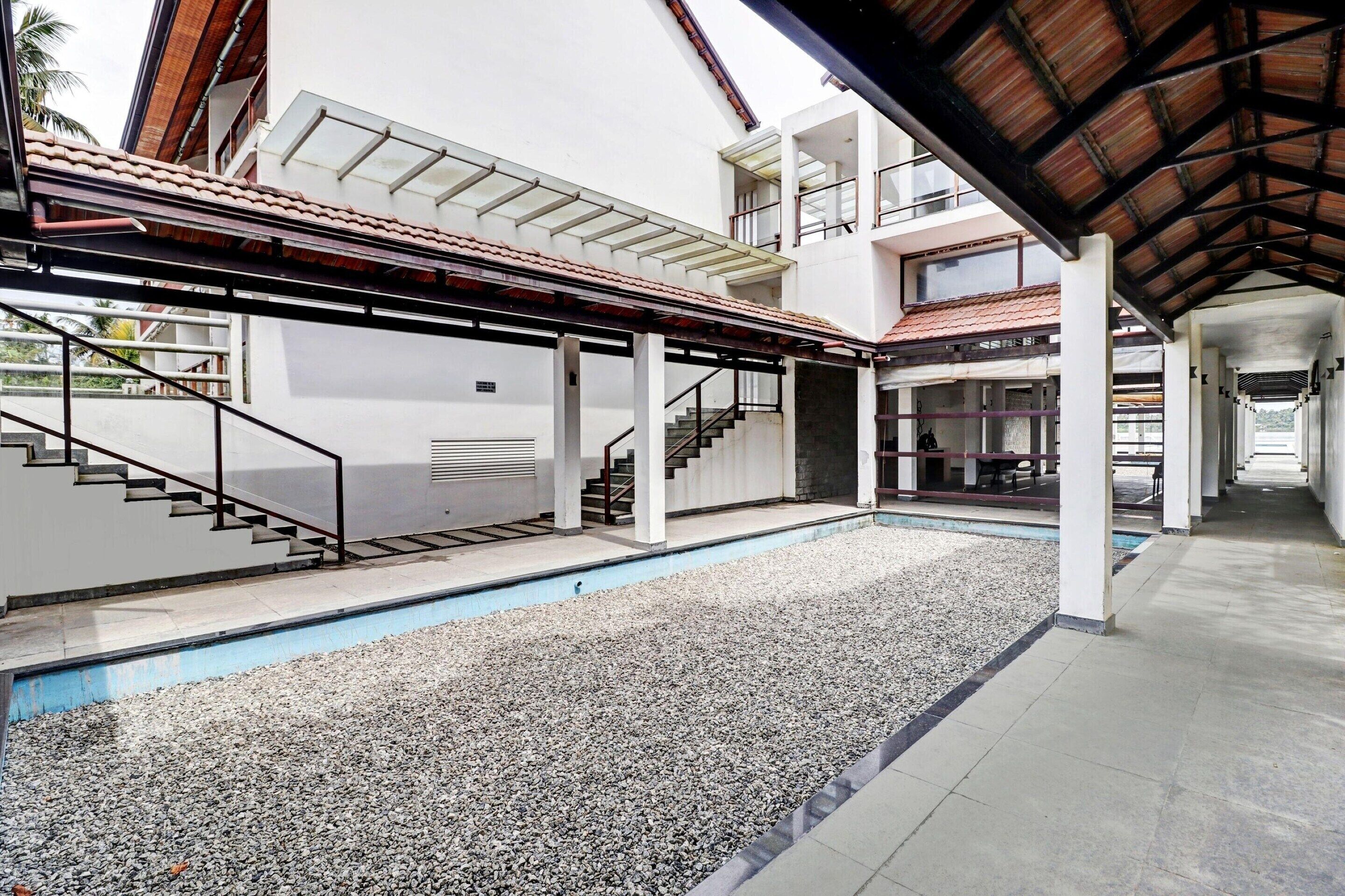 Um edifício moderno com piscina, área externa coberta e várias escadas.