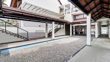 Um edifício moderno com piscina, área externa coberta e várias escadas.