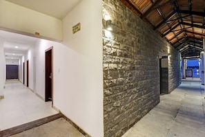 Un pasillo con pared de piedra, puertas de madera y un letrero que indica las habitaciones 101 a 104.