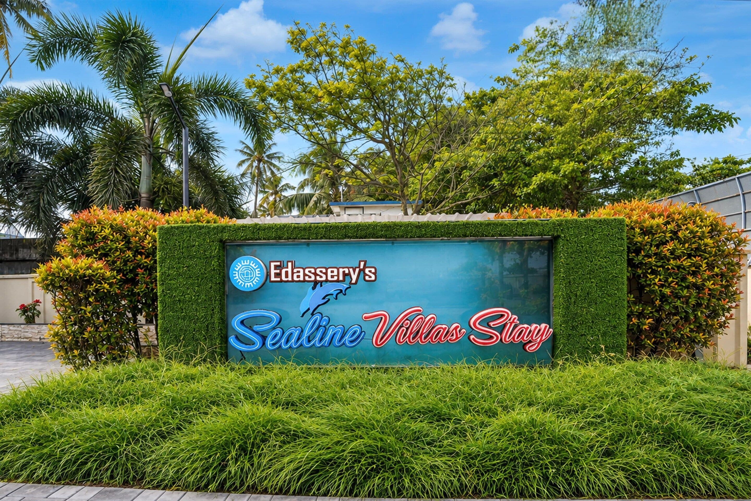 Skilt for Edassery's Sealine Villas, med logo og en grafisk gengivelse af en delfin.