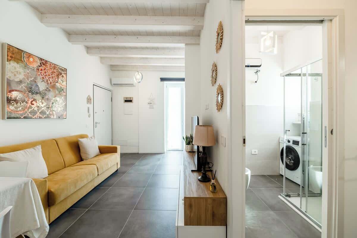 Un salon moderne avec un canapé, une table basse et un tableau accroché au mur.