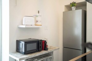 A kitchen with a microwave, toaster, and a refrigerator. - KeyRoom • Patio & Parking near Lake Como (Como)