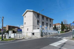 A building with a parking sign and a pedestrian crossing sign. - KeyRoom • Patio & Parking near Lake Como (Como)