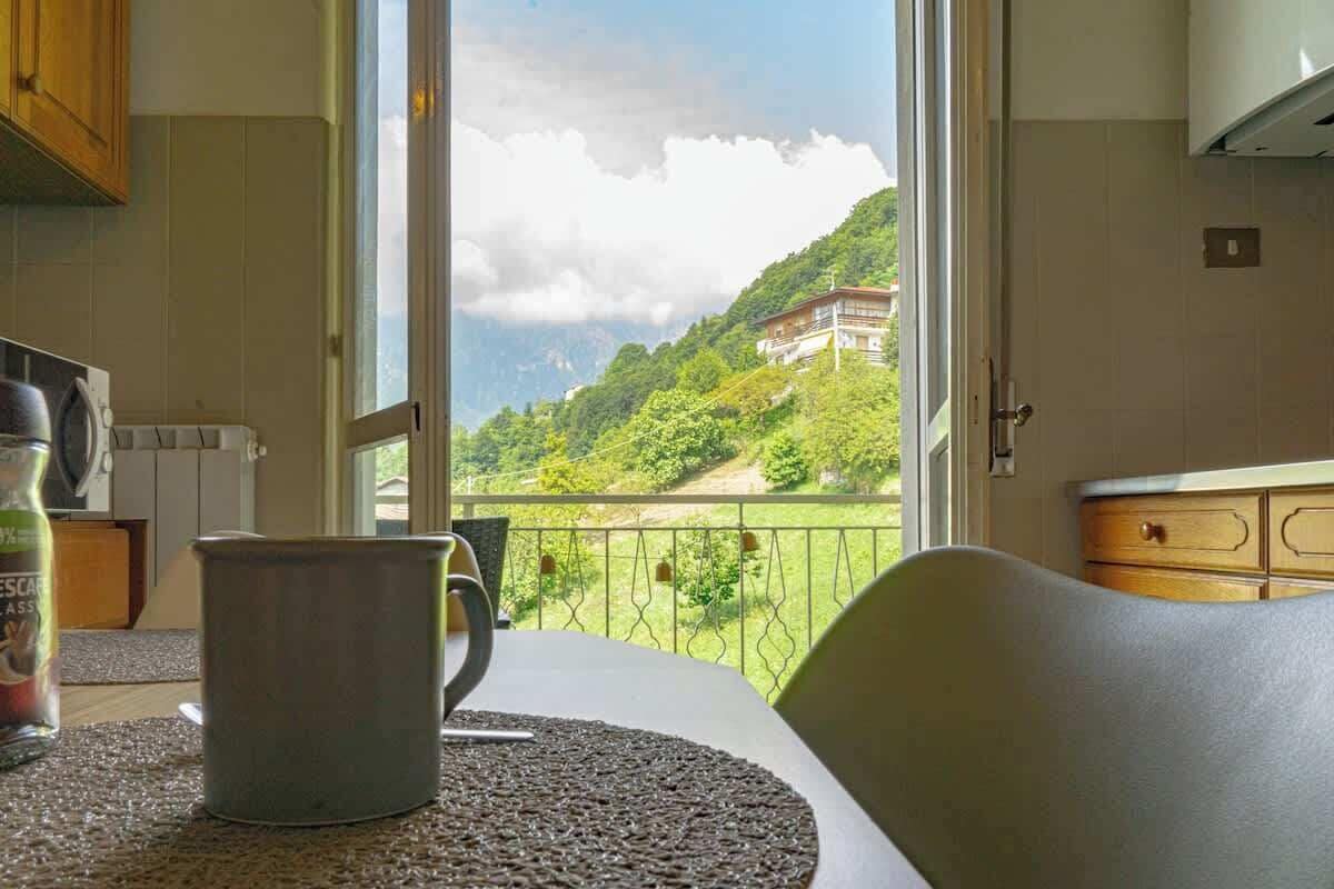 Una cucina con vista su un paesaggio montano attraverso un'ampia finestra.