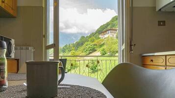 Una cucina con vista su un paesaggio montano attraverso un'ampia finestra.