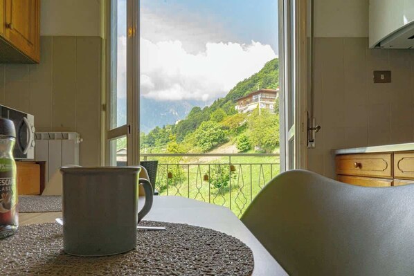 A kitchen with a view of a mountainous landscape through a large window.