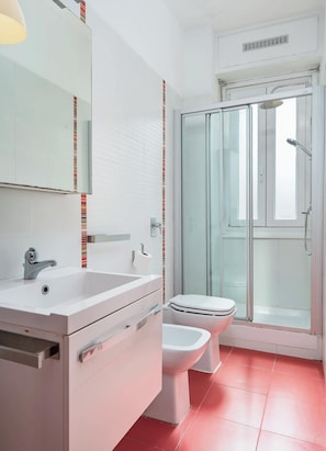 A modern bathroom with a white sink, toilet, and shower. - Porta Venezia Apt: 30s to Metro, Easy Airport (Milan)