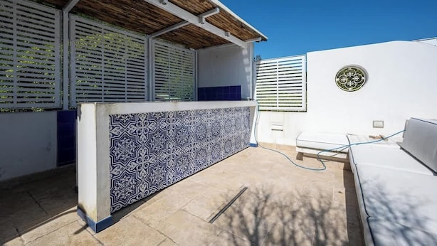 A modern outdoor area with a patterned counter, a white sofa, and a wooden ceiling. - Above the Ruins - a Dream of Baia (Bacoli)