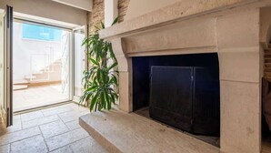 A room with a fireplace, a staircase leading to an outdoor area, and a potted plant. - Above the Ruins - a Dream of Baia (Bacoli)