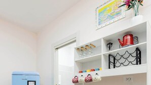 A compact kitchenette with a blue refrigerator, a coffee maker, and a kettle on the counter. - Comfy&Stylish Apt in Rome (Rome)