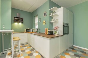 A compact kitchen with a central island, a microwave, a coffee maker, and a refrigerator. - Holi Rome - Bright&Comfy apt inTrastevere (Rome)