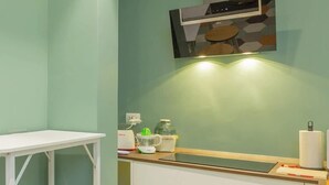 A kitchen with a white countertop, stools, and a microwave. - Holi Rome - Bright&Comfy apt inTrastevere (Rome)