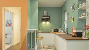 A compact kitchen with a microwave, a small refrigerator, and a bar stool. - Holi Rome - Bright&Comfy apt inTrastevere (Rome)