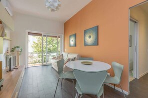 A modern living room with a sofa, a dining table with chairs, and artwork on the wall. - Holi Rome - Bright&Comfy apt inTrastevere (Rome)