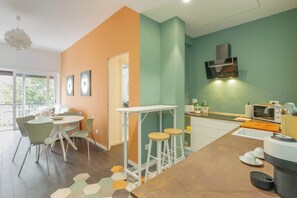 A modern kitchen with a dining area, a bar stool, and a microwave. - Holi Rome - Bright&Comfy apt inTrastevere (Rome)
