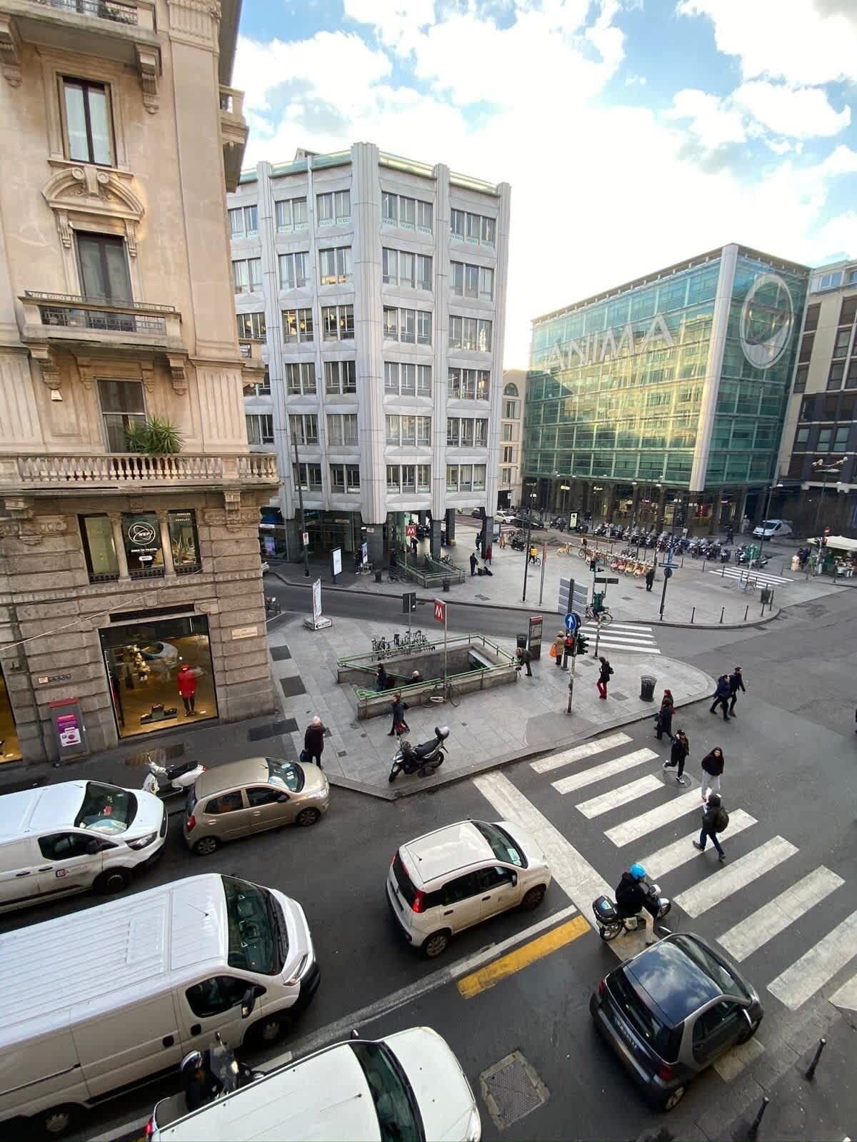 Eine belebte Kreuzung in der Stadt mit Autos und Fußgängern.