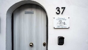En hvid dør med metalgreb, nummer '37' over døren, og en velkomstskilt for Casanova Bridge.