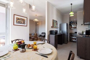 Eine moderne Küche mit Essbereich, ausgestattet mit Kühlschrank, Mikrowelle und Kaffeemaschine auf der Arbeitsfläche.